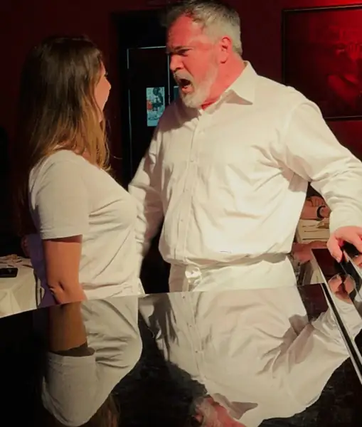 Un cantante de La Castafiore, con camisa blanca, canta junto al piano de cola