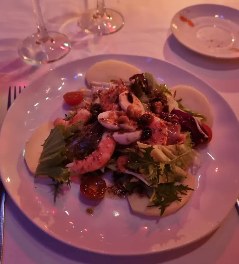 Plato de la carta de La Castafiore servido en mesa con copas de vino