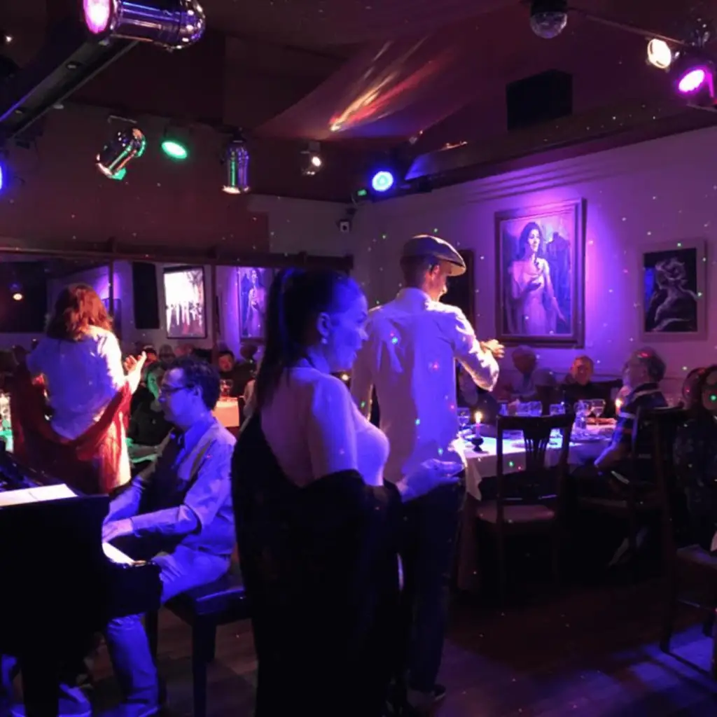 Grupo celebrando en la sala de La Castafiore, con piano y cantantes en directo